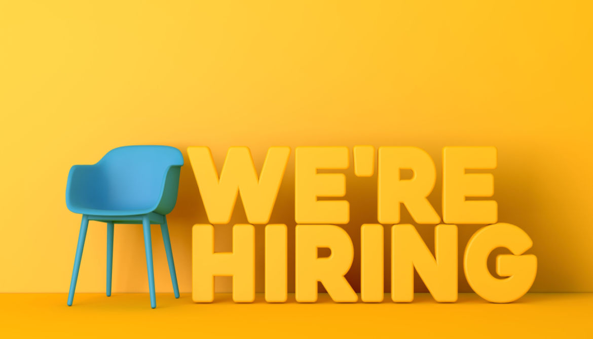 yellow wall blue chair we're hiring