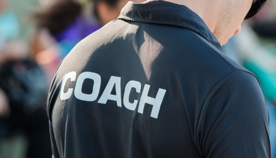 View of the back of a coach wearing a black shirt