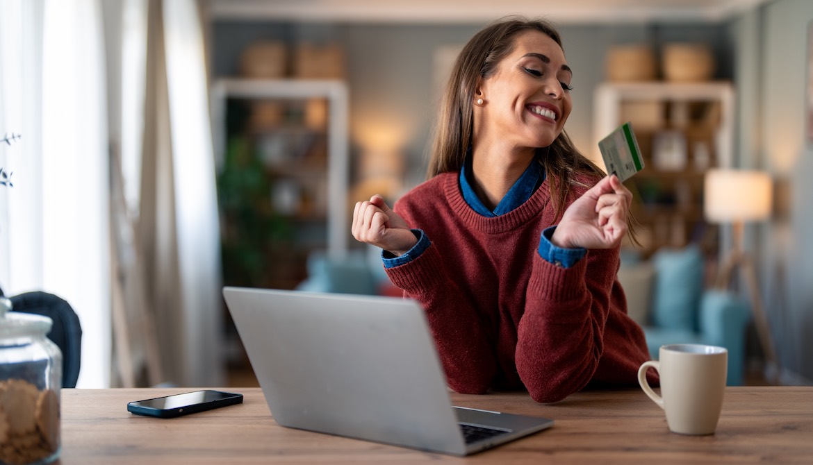 happy young woman reviewing earned credit card rewards