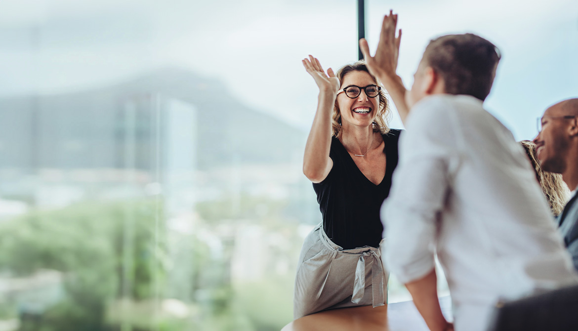 woman and man high-fiving over a table