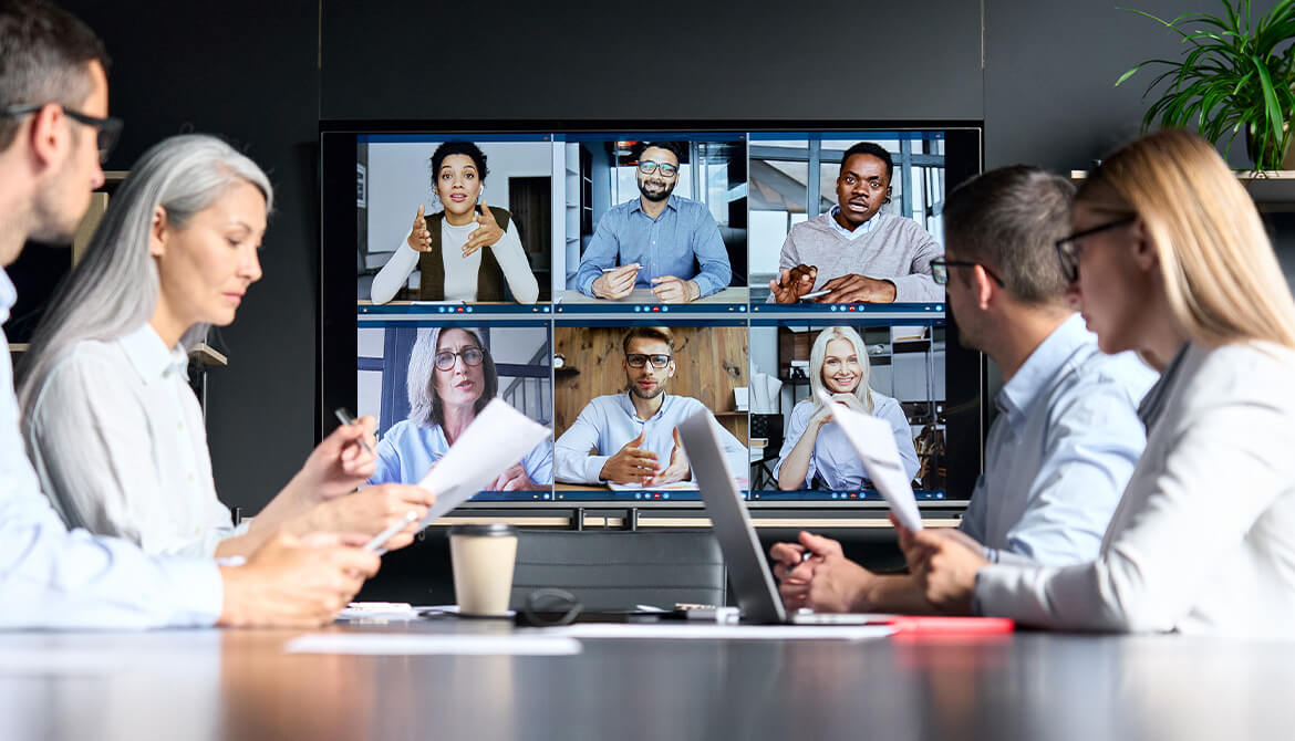 Board members sitting around a large screen showing the board portal for a meeting