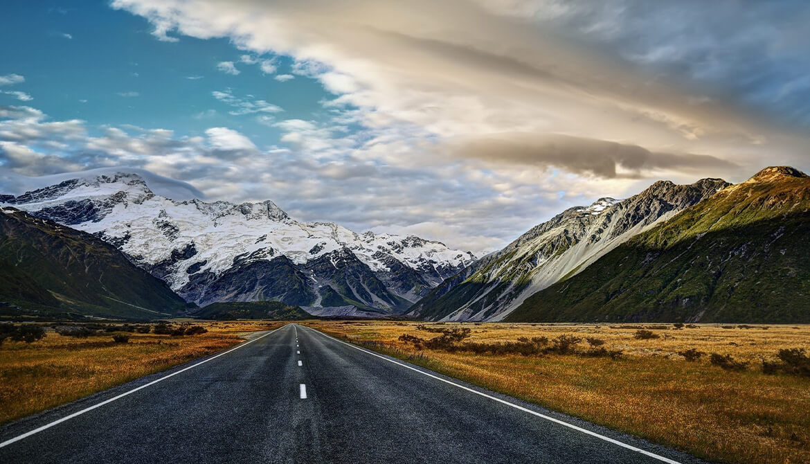 road leading up to whitecapped mountains