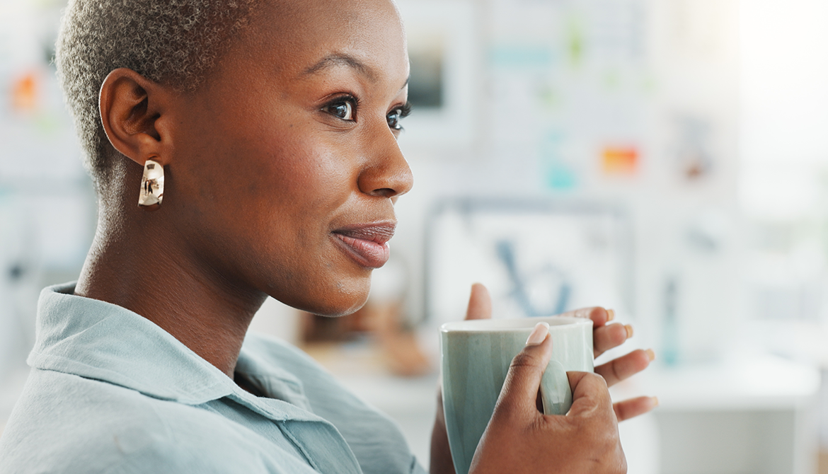 woman looking reflective holding a cup of coffee