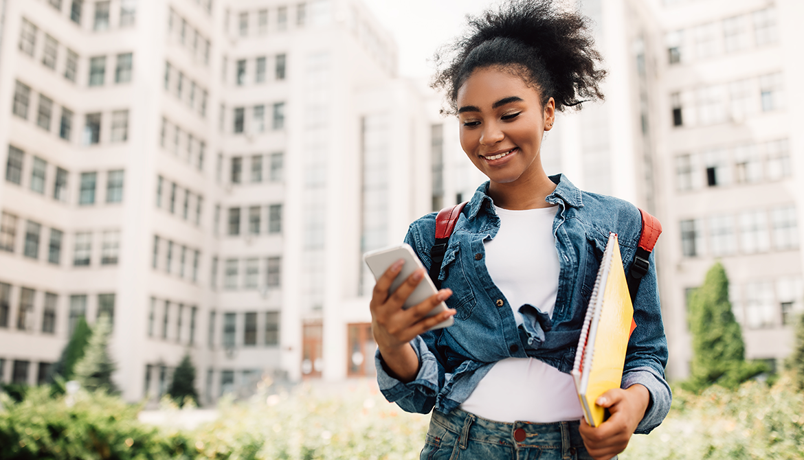 Gen Z lady walking down street looking at cell phone