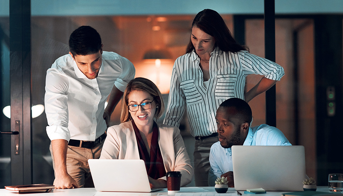 Group of individuals looking at laptops