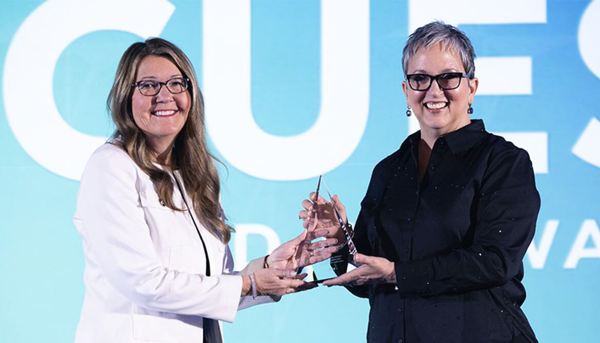 Julia receiving the award from Heather McKissick, CUES' CEO