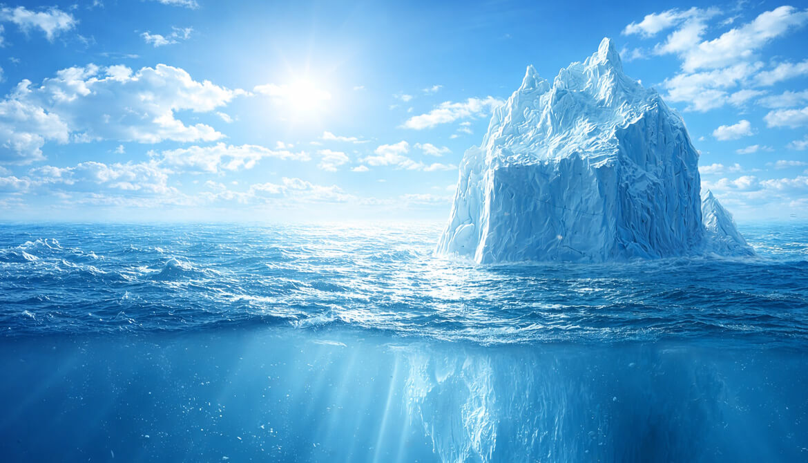 iceberg standing up out of the water with bright blue skies 