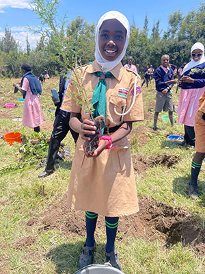 African girl holding a tree sapling