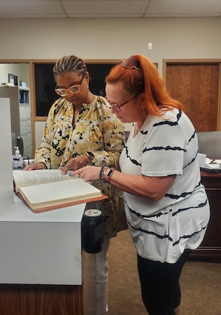 women look at history book for credit union