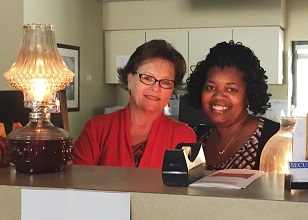 Financial Services Representative II Betty Hines and Financial Services Manager Mona Barfield do credit union work by hurricane lamp in the wake of Hurricane Matthew