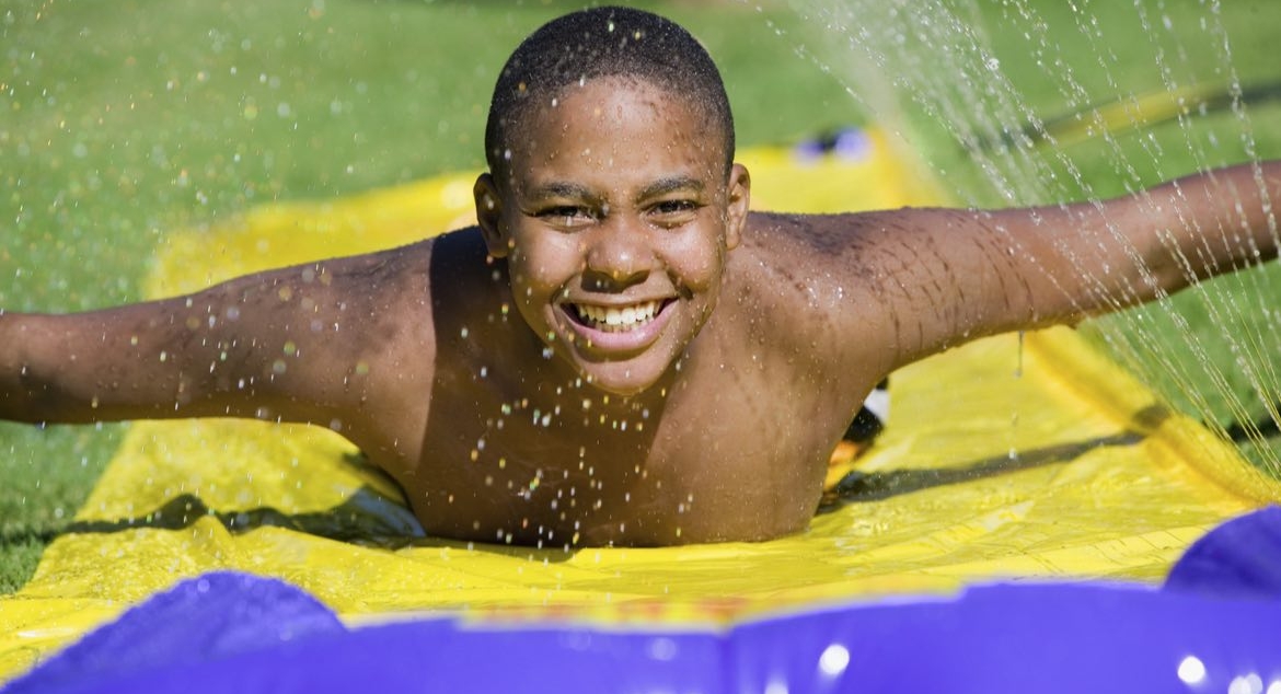 boy playing on slip n slide