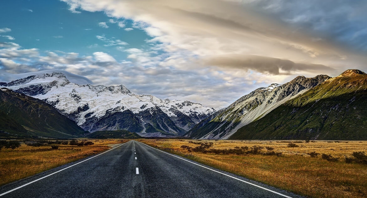 road leading up to whitecapped mountains