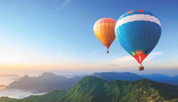 colorful hot air balloons soaring over mountains