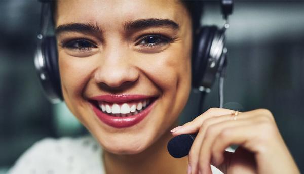 smiling young woman using headset in call center