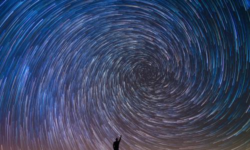 Man Pointing North in a spiral star trail
