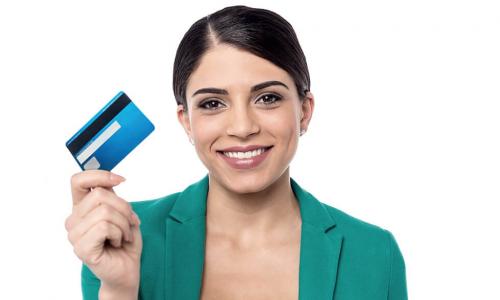 Female credit union staff holding up a new credit card
