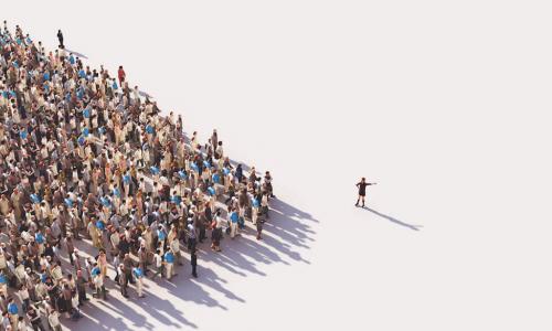 Large group of people in an arrow formation pointing toward a leading figure standing apart from the crowd