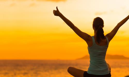 Healthy woman celebrating during a beautiful sunset Happy and Free Illustrates self-care balance and employee wellnesss