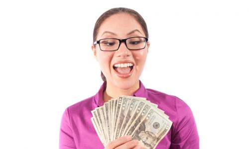 woman in bright pink shirt holding cash