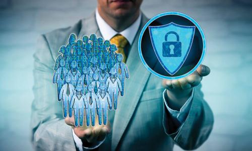 businessman holding a padlock and shield icon representing cybersecurity in one hand and an illustrated group of employees in the other