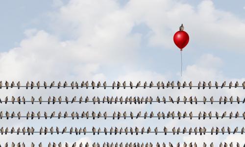birds on a wire with one rising above the crowd on a red balloon