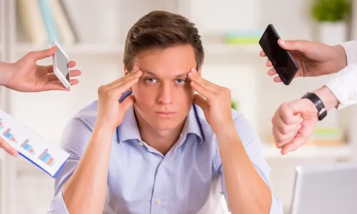 Stressed manager in his office being asked to do too many tasks at once