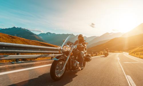 motorcycle rider driving along the open road in front of a friend