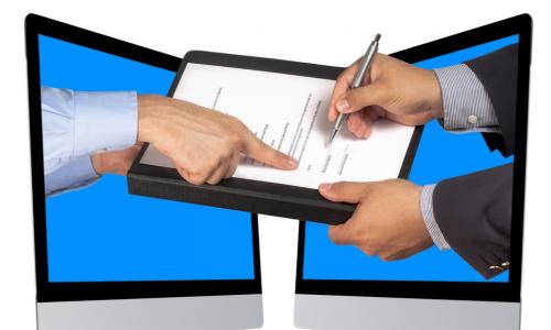 hands coming out of computers taking an e-signature on a contract
