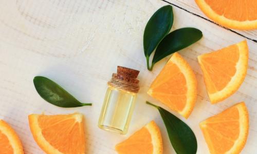 orange slices with a vial of essential oil and fragrant leaves