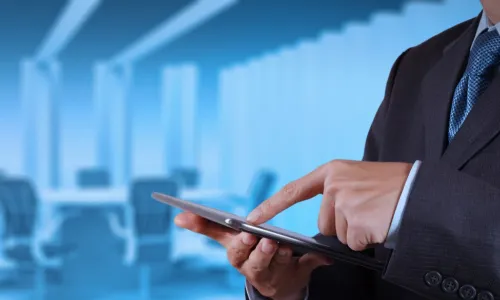 director using a tablet near the board table