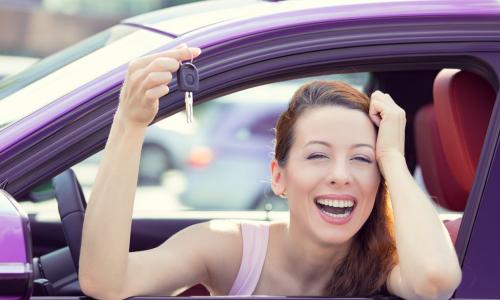 happy woman in purple car with keys