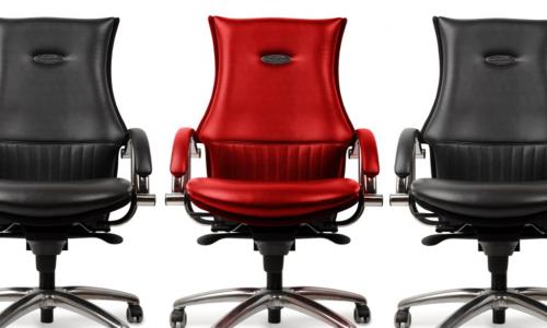 black executive chairs on either side of a red executive chair