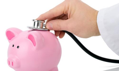 Doctor listening to a piggy bank with a stethoscope