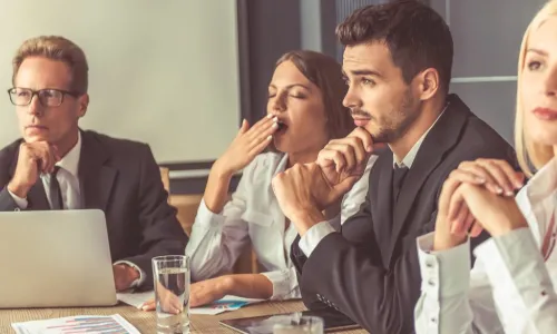 group of directors one of whom is yawning with boredom