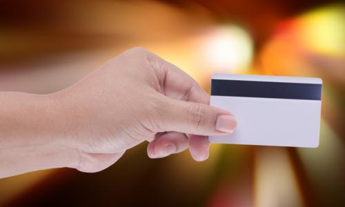 hand holding credit card with magnetic stripe showing