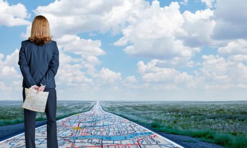 Professional woman stands on a map leading forward