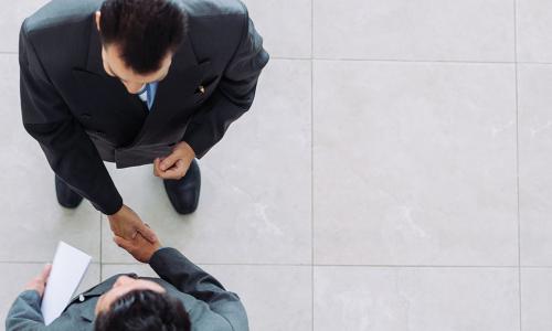 overhead view of two businessmen shaking hands in agreement