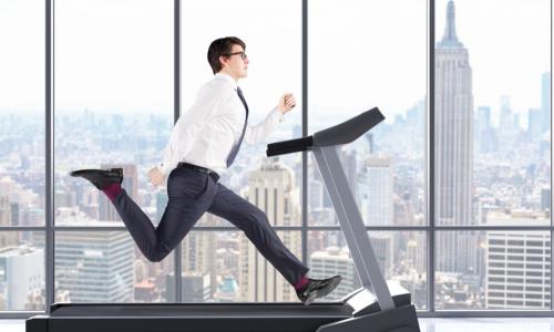 businessman running on a treadmill at a fast pace