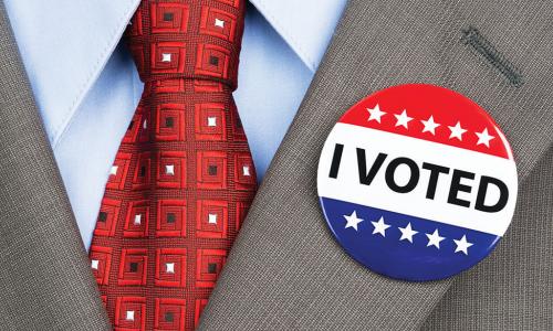 red tie and suit lapel with I Voted button