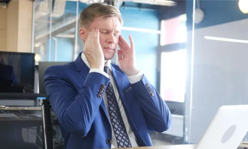 businessman with a headache rubbing his temples