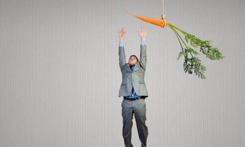Funny image of businessman jumping for a carrot
