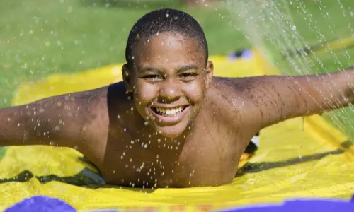 boy playing on slip n slide