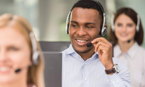 young African American call center employee wearing headset helps customer on phone