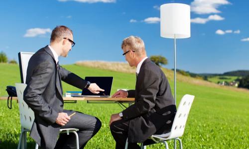 business men meeting outside with table, laptop and lamp