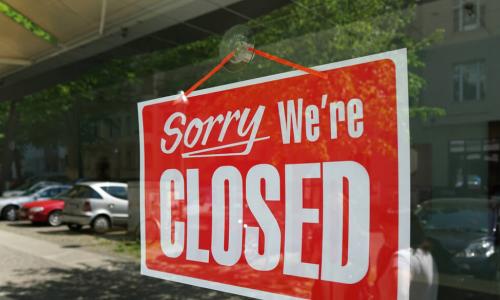 red sign in window of a business that says sorry we’re closed