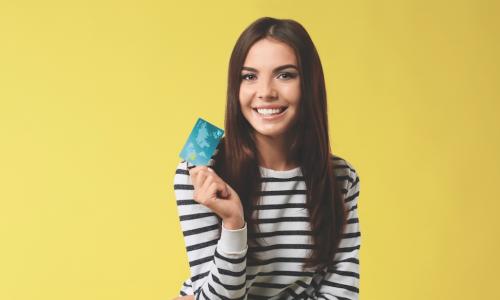 smiling young woman holding new credit card