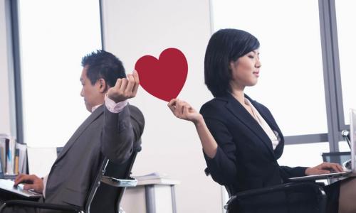 executives passing a red paper heart between their workspaces