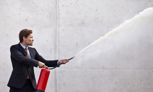 executive using fire extinguisher