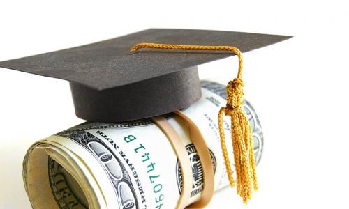 mini graduation cap on roll of money