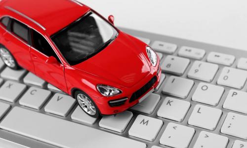 red toy car sits on white computer keyboard